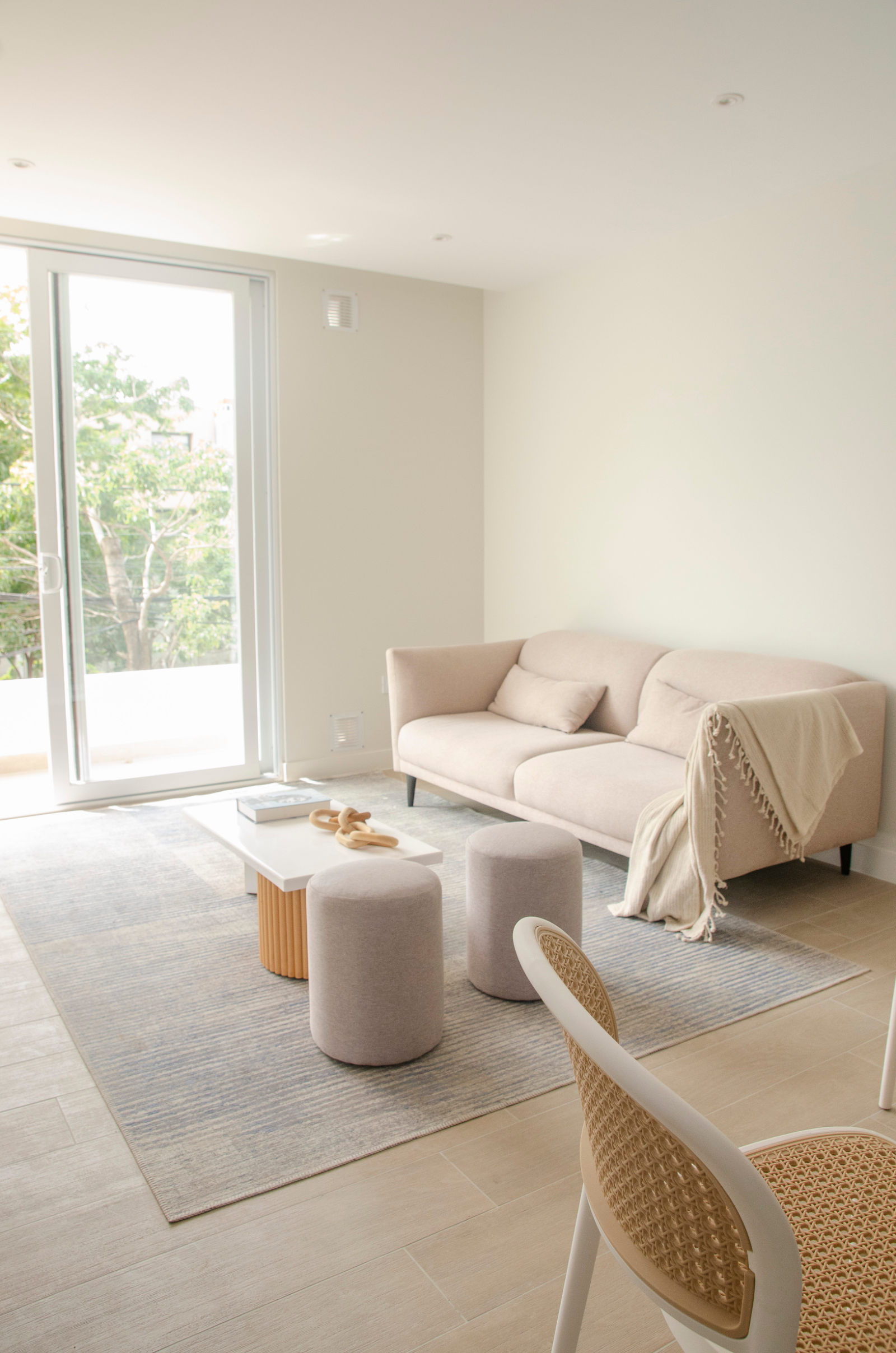 Living del departamento modelo, con ventanal al balcón y luz natural